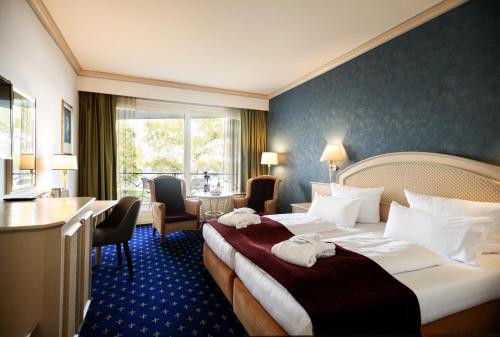 um quarto de hotel com duas camas e uma mesa e cadeiras em Hotel Dieksee - Collection by Ligula em Malente