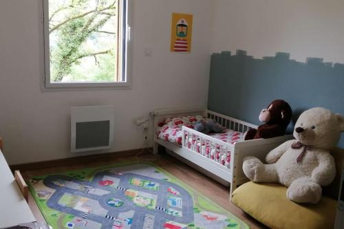 - une chambre pour enfants avec un lit bébé et un ours en peluche dans l'établissement Maison bois avec terrasse sur pilotis, à Cazals