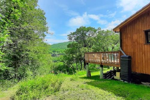 une terrasse sur le côté d'une maison avec des arbres dans l'établissement Maison bois avec terrasse sur pilotis, à Cazals