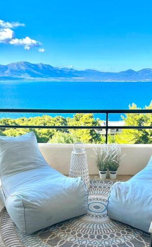 a balcony with two pillows and a view of the water at SeaTerra Boutique suite in Kalamos