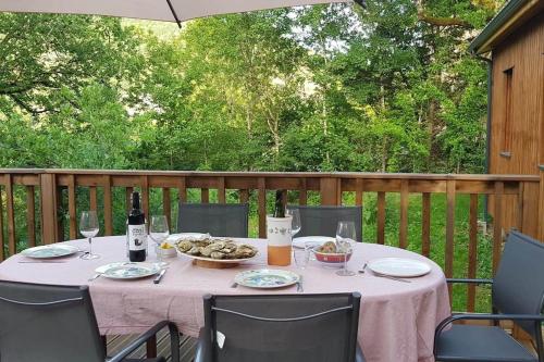 - une table avec de la nourriture et du vin sur une terrasse dans l'établissement Maison bois avec terrasse sur pilotis, à Cazals
