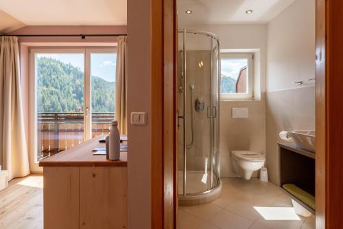 a bathroom with a shower and a toilet and a window at Villa Gottfried B&B in Eggen