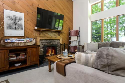 a living room with a couch and a fireplace at Okemo Westwood Condo condo in Ludlow