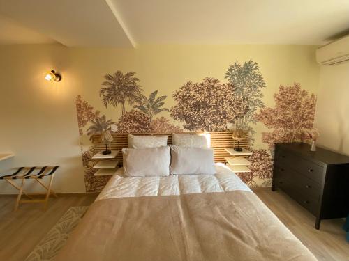ein Schlafzimmer mit einem Bett und einer Wand mit Pflanzen in der Unterkunft Bubble rooms Chambres confortables en plein centre de Dieulefit in Dieulefit