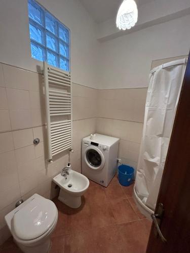 uma casa de banho com um WC e uma máquina de lavar roupa em Casa vacanze nel cuore del centro storico: il tuo rifugio autentico! em Colle Val D'Elsa