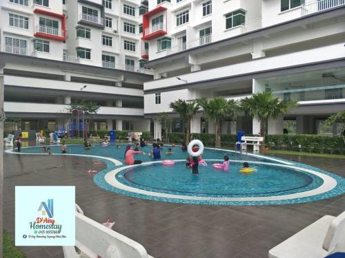 um grupo de pessoas em uma piscina em um edifício em D'Aisy Homestay Sepang Klia Nilai em Sepang