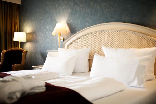 a hotel room with a bed with white pillows at Hotel Dieksee - Collection by Ligula in Malente