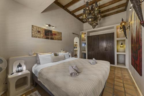 a bedroom with a large bed and a chandelier at Tingafa - Apartamento rural con piscina in Las Breñas