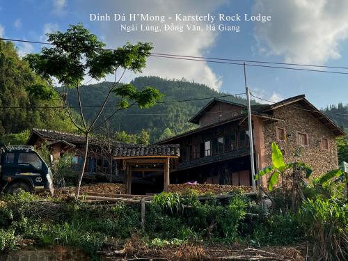 a house with a truck parked in front of it at Dinh Đá H'Mông - Karsterly Rock Lodge in Dồng Văn