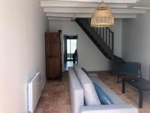 sala de estar con sofá y escalera en Le 20 Les Terrasses. Maison de bord de Loire, en Chalonnes-sur-Loire