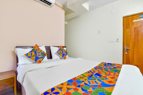 een slaapkamer met een bed met een kleurrijk dekbed bij FabHotel Vishwa in Ahmedabad