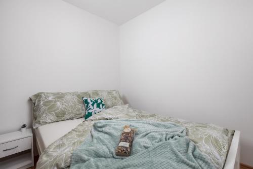 ein Bett mit einer Decke und einer Fernbedienung darauf in der Unterkunft Apartment KATI&ANA in Rijeka