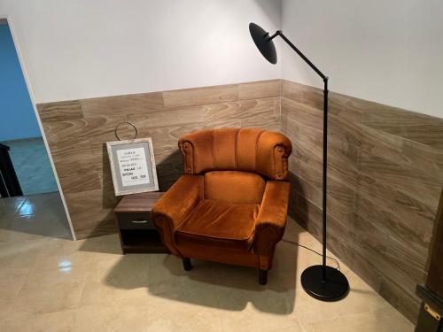a brown chair sitting next to a floor lamp at Andimi Pozo Nuevo in Toledo