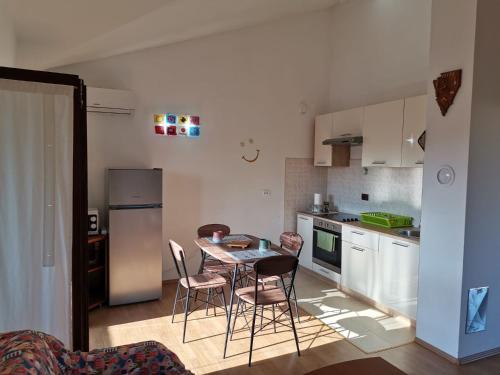 kuchnia ze stołem, krzesłami i lodówką w obiekcie Appartement Sonia w Fažanie