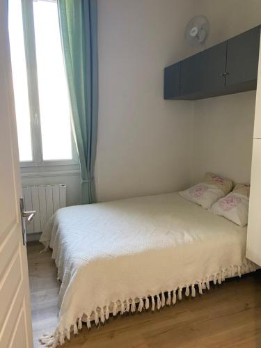 białe łóżko w pokoju z oknem w obiekcie Chez Tony w mieście Périgueux