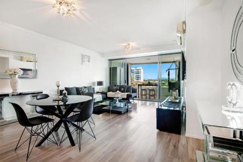 a living room with a table and chairs at Couture Comfort - Luxe Chanel Themed Apartment in Gold Coast
