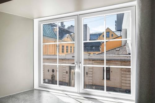 een lege kamer met een raam met uitzicht op een stad bij numa I Hallen Apartments in Oslo