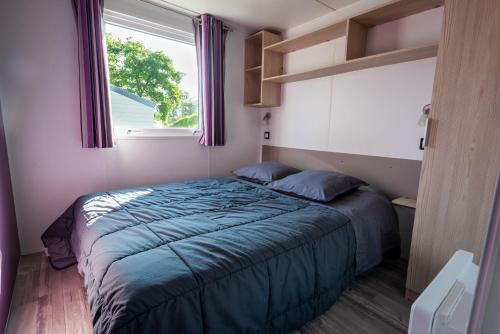 a small bedroom with a bed and a window at Camping les falaises de Toussaint in Toussaint