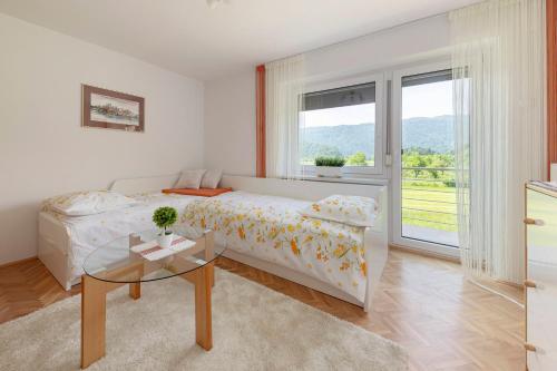 una camera bianca con un letto e un tavolo in vetro di Hiša v zelenem a Bled