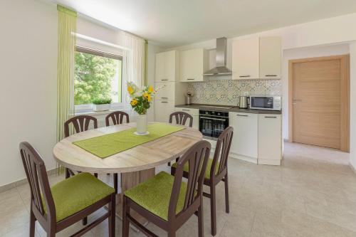 una cucina e una sala da pranzo con tavolo e sedie di Hiša v zelenem a Bled