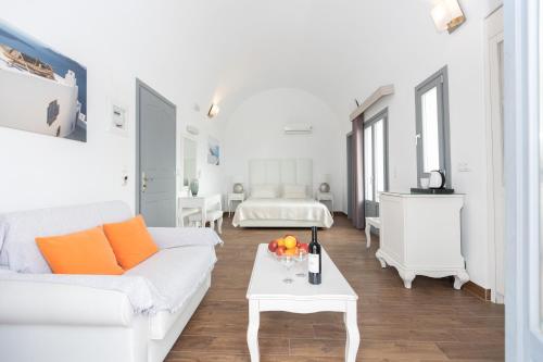 a white living room with a white couch and a table at Hotel Star Santorini in Megalochori