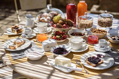 einen Tisch mit Teller und Schalen mit Lebensmitteln in der Unterkunft Dimora Santa Margherita - Relais di Charme in Cinigiano