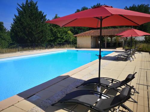 una piscina con sillas y sombrillas junto a una piscina en Chambre d'hôtes Tournesol, piscine en campagne gersoise, en Lias-dʼArmagnac