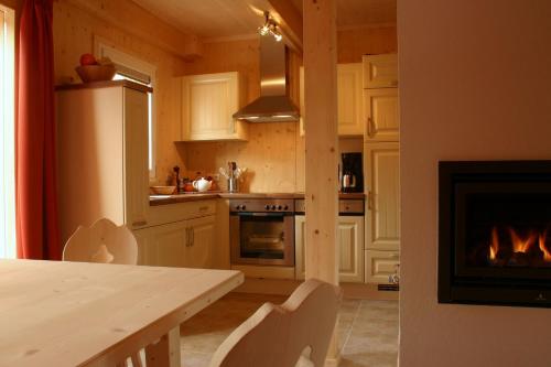 a kitchen with a table and a fireplace at Almchalet in Stadl an der Mur