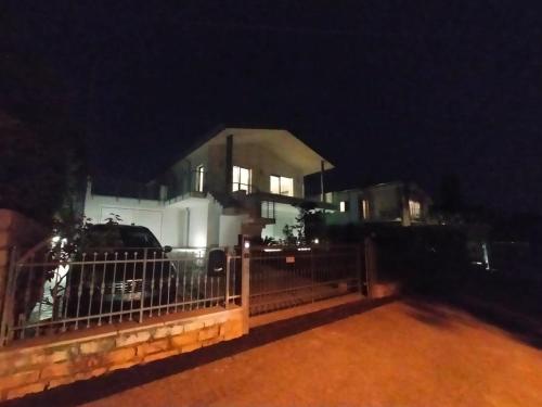 Ein weißes Haus hinter einem Zaun in der Nacht in der Unterkunft Villa Oliveto 24 in Bardolino