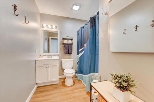 baño con aseo y cortina de ducha azul en High-Flying Haven 4bd 2 bath, en Enterprise