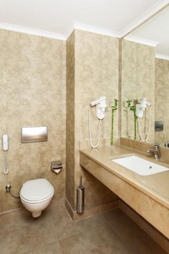 a bathroom with a toilet and a sink at WOW Airport Hotel in Istanbul