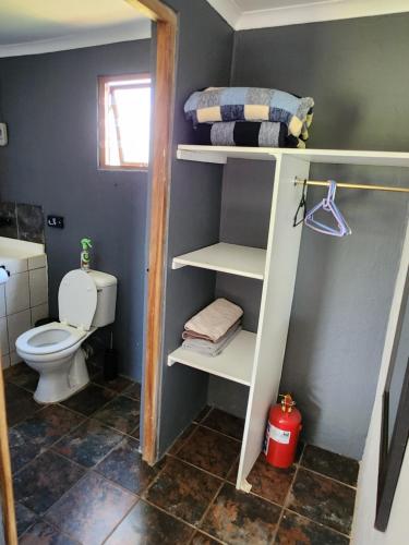 a bathroom with a toilet and a bunk bed at Sky Cottage in Brits
