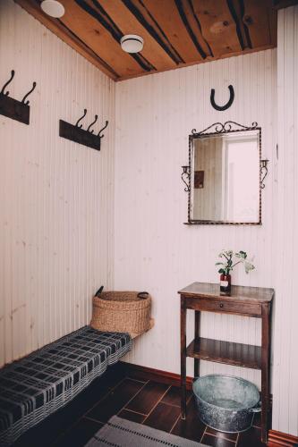 a room with a bench and a table and a mirror at Vääksyn Apteekinmajoitus in Vääksy