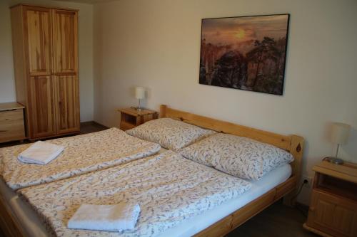 a bedroom with a bed and a painting on the wall at Apartmány U Zvoničky in Prachov