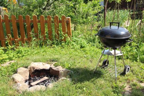 a grill sitting on a stand next to a fire at Apartmány U Zvoničky in Prachov