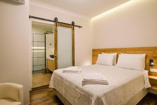 a bedroom with a bed with a chair and a mirror at Kouketa Luxury in Corfu Town