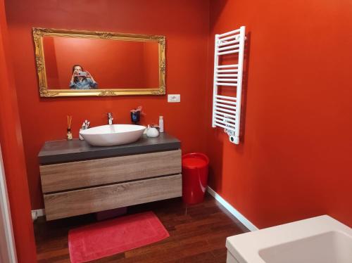 eine Person, die ein Bild von einem Badezimmer mit orangefarbener Wand macht in der Unterkunft VILLA FOR RYDER CUP in Guidonia