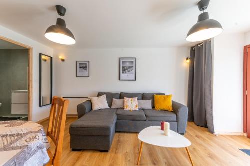 a living room with a couch and a table at Les 3 Chamois - Station de ski accessible à pied in Les Gets