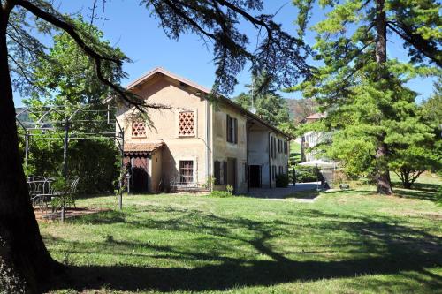 ein altes Haus mit einem Baum im Hof in der Unterkunft Villa Lucini 1886 "La Dolcevita" Cottage 2, close to Lake Como and Milan in Calco