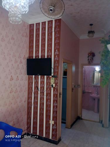 a room with a wall with a television on it at الوحيد برأس البر in ‘Izbat al Burj