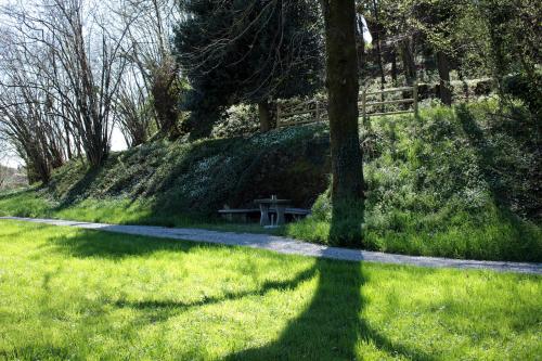 a bench sitting in the grass next to a tree at Villa Lucini 1886 "La Dolcevita" Cottage 2, close to Lake Como and Milan in Calco