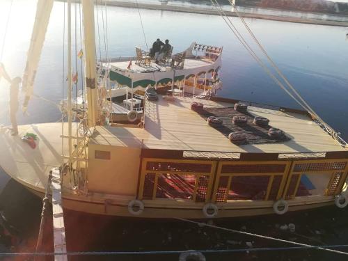 Ein Boot im Wasser mit zwei Leuten drauf. in der Unterkunft Sailing boat in Assuan