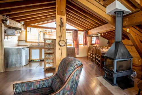 a living room with a fireplace and a couch and a stove at Les Chalets du Cocoon in La Plagne