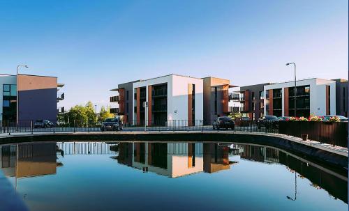 a bridge over a body of water in front of buildings at Gilužio Rivjera in Vilnius