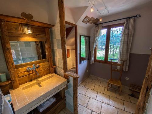 uma casa de banho com uma banheira de madeira e um lavatório em La Fernande em Baratier