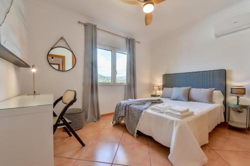 1 dormitorio con 1 cama grande y espejo en Villas Guzman - BELLISSIMA, en Calpe