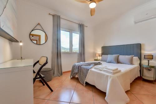 sypialnia z dużym łóżkiem i lustrem w obiekcie Villas Guzman - BELLISSIMA w mieście Calpe