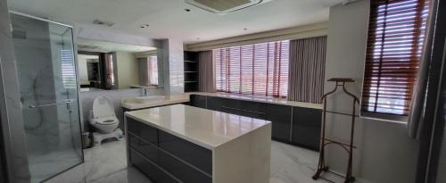 a bathroom with a sink and a shower and a toilet at Poblacion Penthouse Suite with Private Roofdeck in Manila