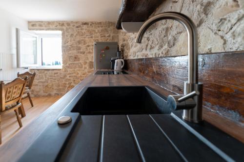 a kitchen with a sink and a faucet at Stonehouse Mali Lukoran in Lukoran