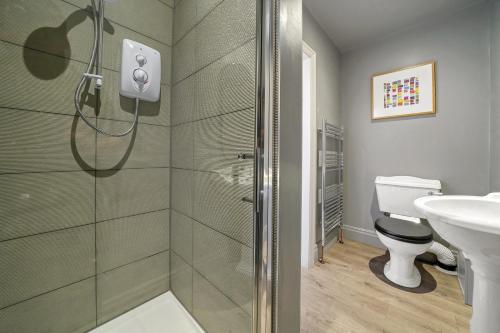 a bathroom with a shower and a toilet and a sink at A selection of apartments in Golborne Business and Leisure WIFI Parking by Stone Pit Apartments in Golborne